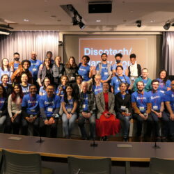 BetaNYC staff and School of Data volunteers pose for a group photo on a stage at CUNY School of Law.