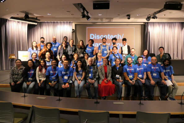 BetaNYC staff and School of Data volunteers pose for a group photo on a stage at CUNY School of Law.