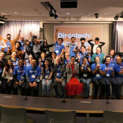 2024 School of Data Volunteers pose together on a stage in an auditorium at CUNY School of Law.